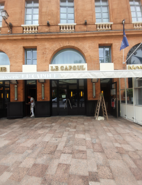 Peintre pour application peinture sur la boiserie de la vitrine d'un restaurant à Toulouse place WILSON